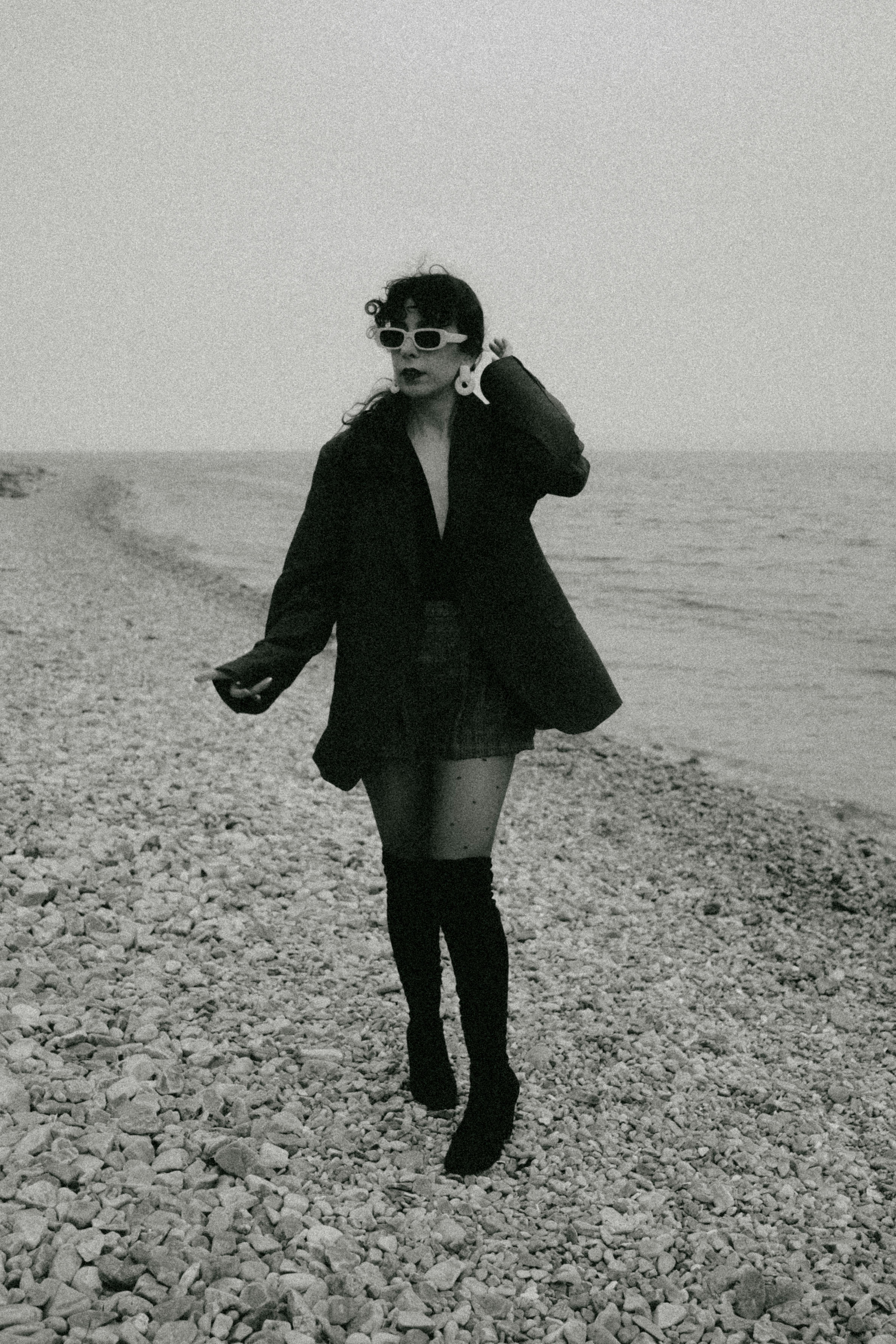 1920s coastal scene, woman in sunglasses on a beach, vintage aesthetic