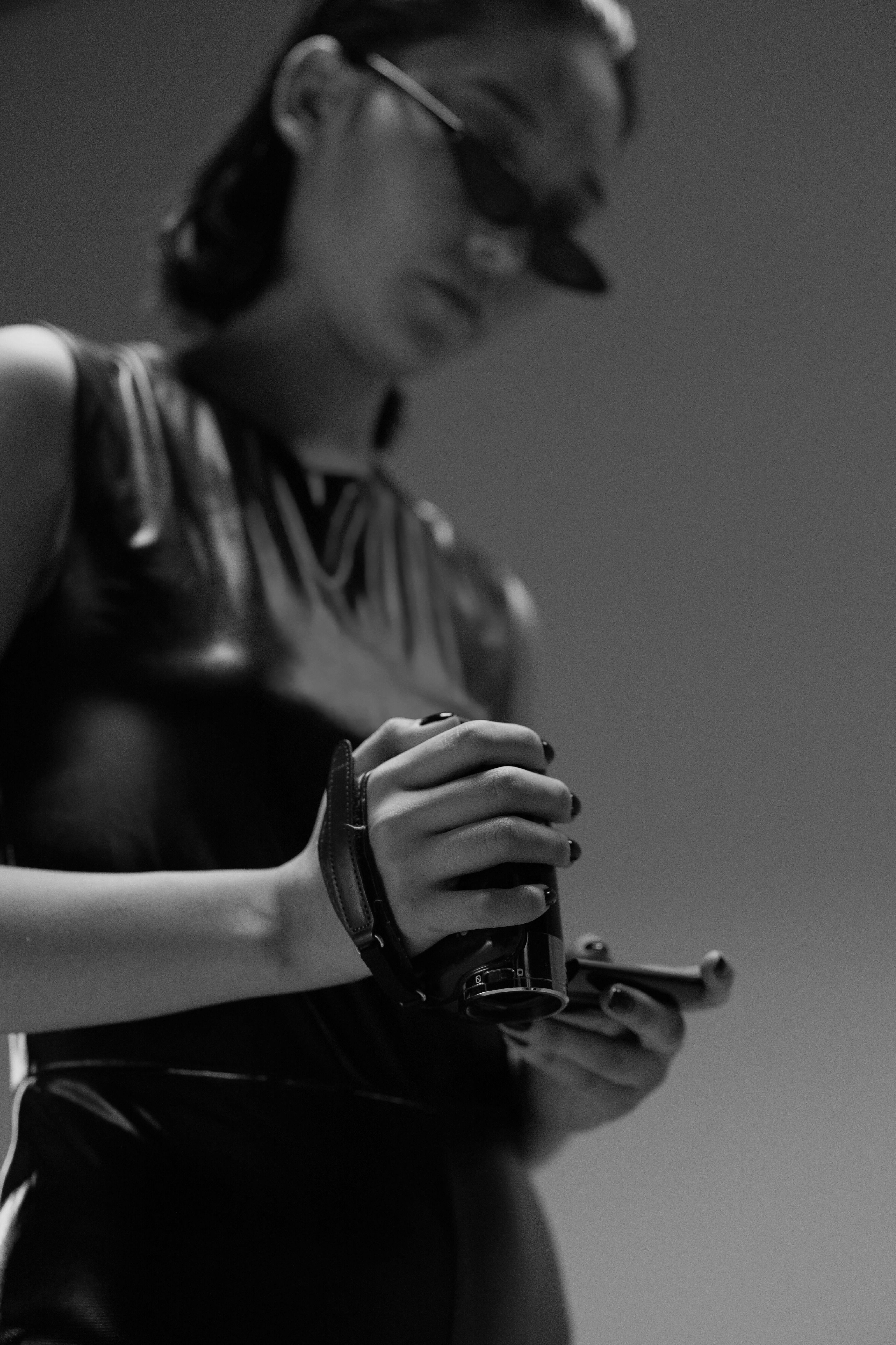 Dramatic black and white photograph of a figure wearing dark sunglasses in shadow