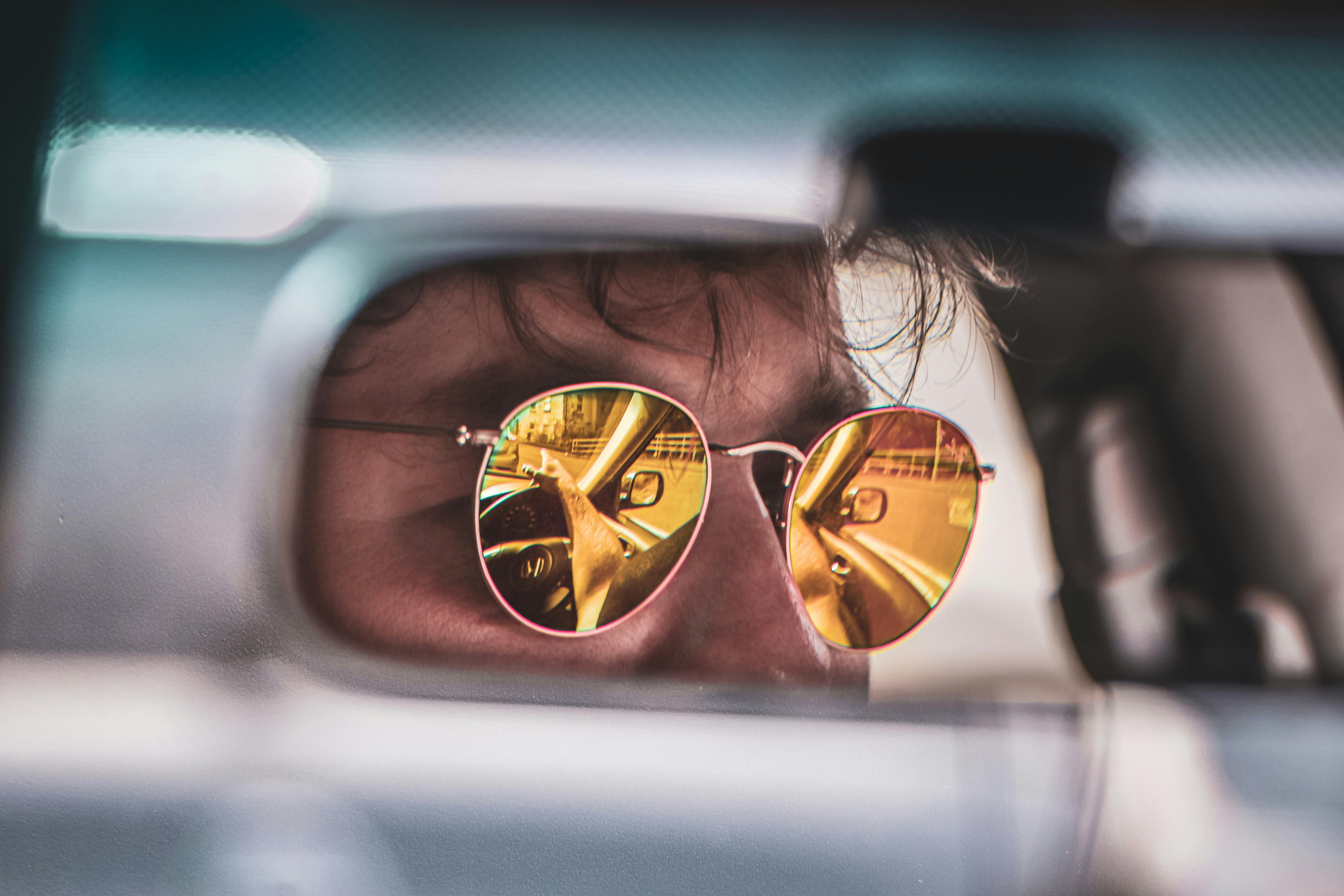 Person in mirrored sunglasses, reflection visible in the lens